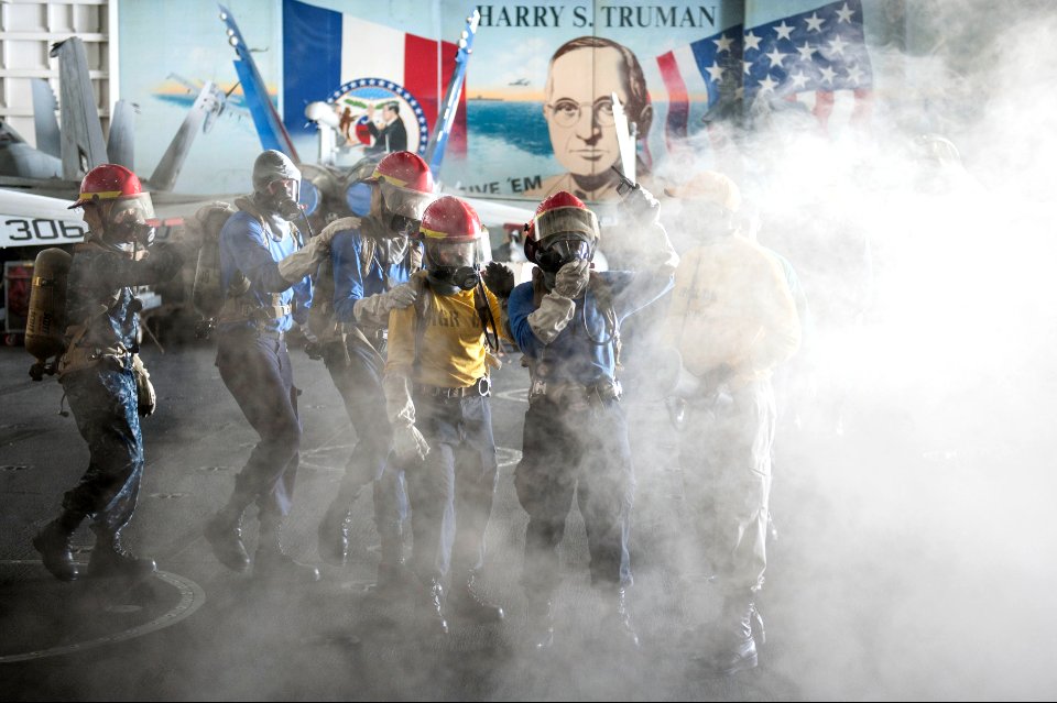 U.S. Sailors fight a simulated fire during a general quarters drill in the hangar bay of the aircraft carrier USS Harry S. Truman (CVN 75) March 8, 2014, in the Gulf of Oman 140308-N-ZG705-433