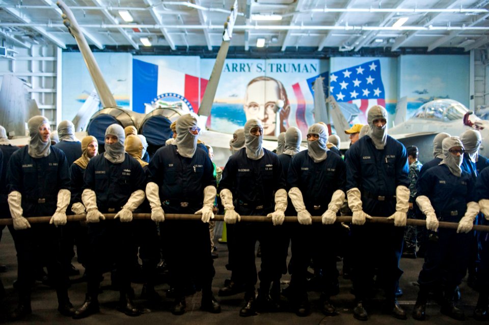 U.S. Sailors man a hose during a general quarters drill in the hangar bay of the aircraft carrier USS Harry S. Truman (CVN 75) in the Persian Gulf Jan. 17, 2014 140117-N-ZG705-007