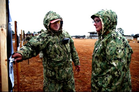 U.S. Navy Utilitiesman 1st Class Luis Alarcon, left, with the 20th Seabee Readiness Group, reviews proper aiming and shot-grouping techniques with Hospital Corpsman 3rd Class Sara Phillips, with Naval Mobile 140211-N-JP566-125