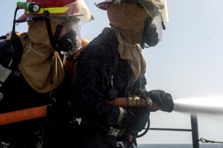 U.S. Sailors man a fire hose during a drill aboard the guided missile cruiser USS Philippine Sea (CG 58) in the Arabian Sea April 5, 2014 140405-N-PJ969-370 photo