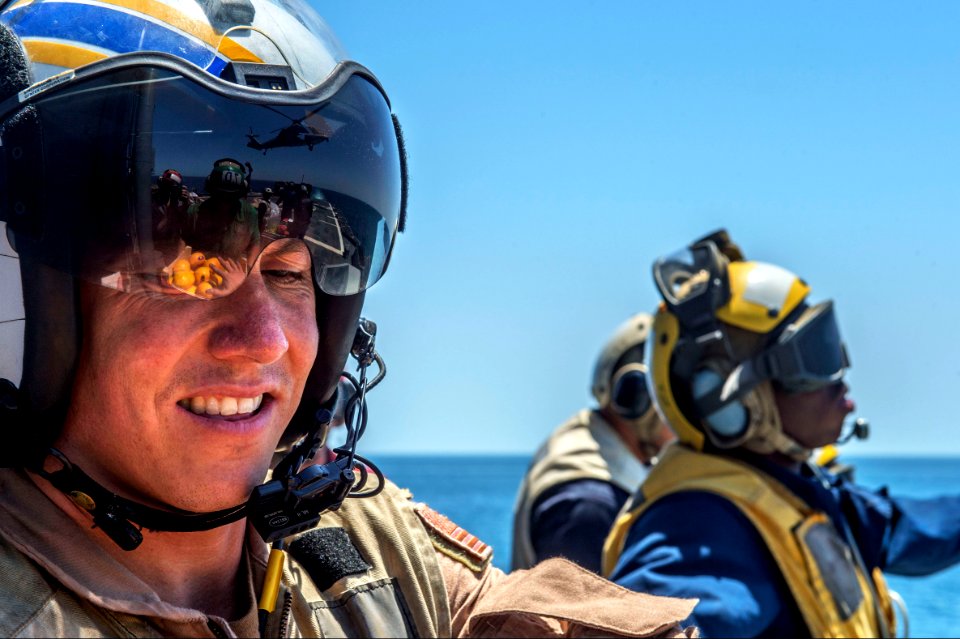 U.S. Navy Lt. Cmdr. Patrick Veith, left, participates in a vertical replenishment aboard the guided missile cruiser USS Philippine Sea (CG 58) in the Arabian Sea April 9, 2014 140409-N-PJ969-103