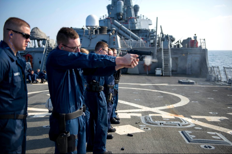 U.S. Sailors fire 9 mm pistols during a small-arms qualification aboard the guided missile destroyer USS Stout (DDG 55) Jan. 18, 2014, in the Mediterranean Sea 140118-N-UD469-163