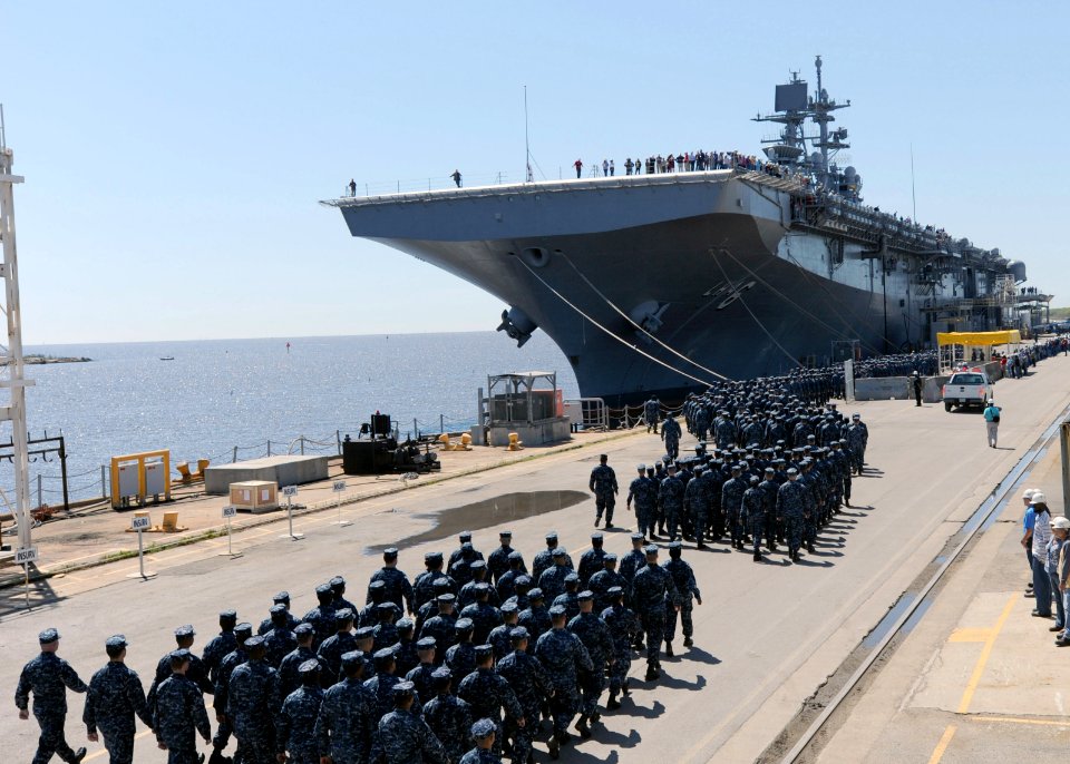 U.S. Sailors and Marines assigned to the amphibious assault ship Pre-Commissioning Unit America (LHA 6) march to the ship at the Huntington Ingalls Industries pier in Pascagula, Miss., April 10, 2014 140410-N-LQ799-033