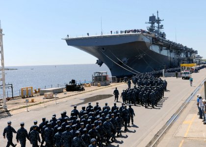 U.S. Sailors and Marines assigned to the amphibious assault ship Pre-Commissioning Unit America (LHA 6) march to the ship at the Huntington Ingalls Industries pier in Pascagula, Miss., April 10, 2014 140410-N-LQ799-033