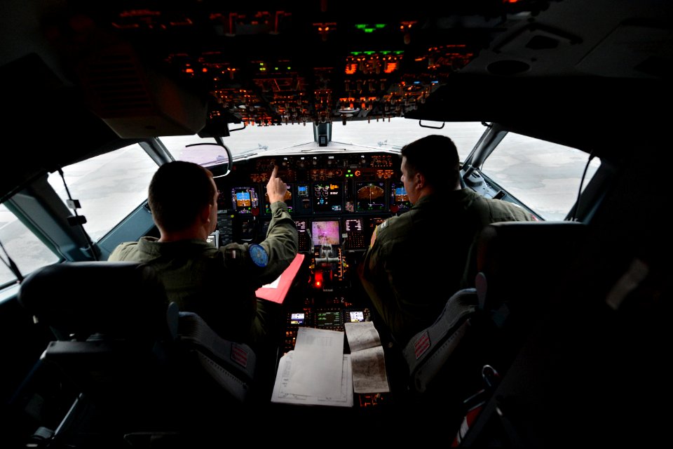 U.S. Navy Lt. j.g. Nick Horton, left, and Lt. Clayton Hunt, naval aviators assigned to Patrol Squadron (VP) 16, perform preflight checks in the flight station of a P-8A Poseidon aircraft before a mission to 140401-N-VD564-054