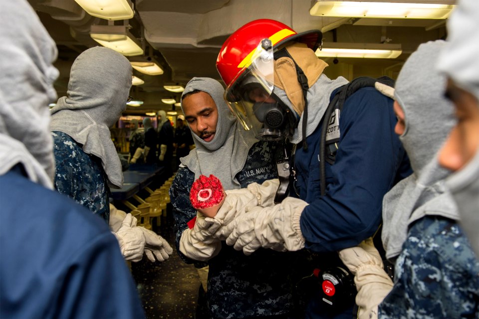 U.S. Sailors simulate an injury during a general quarters drill aboard the amphibious assault ship USS America (LHA 6) Sept 140906-N-MD297-031