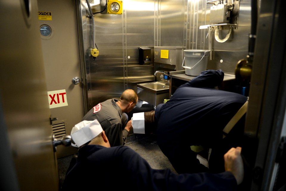 U.S. Sailors accompany a member of the Board of Inspection and Survey (INSURV) as he evaluates the galley aboard the amphibious transport dock ship USS Mesa Verde (LPD 19) Jan. 16, 2014, in the Atlantic Ocean 140116-N-BD629-349
