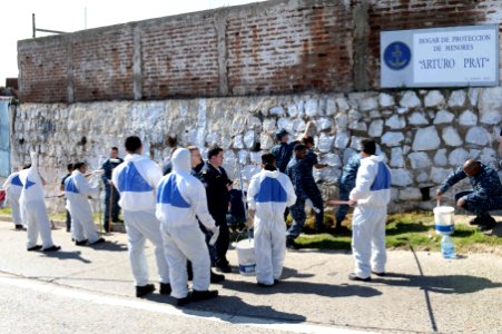 U.S. Sailors assigned to the newly commissioned amphibious assault ship USS America (LHA 6) and Chilean sailors paint an exterior wall at a children's home in Valparaiso, Chile, Aug. 26, 2014, during a community 140826-N-MZ309-057