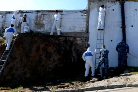 U.S. Sailors assigned to the newly commissioned amphibious assault ship USS America (LHA 6) and Chilean sailors paint an exterior wall at a children's home in Valparaiso, Chile, Aug. 26, 2014, during a community 140826-N-MZ309-037