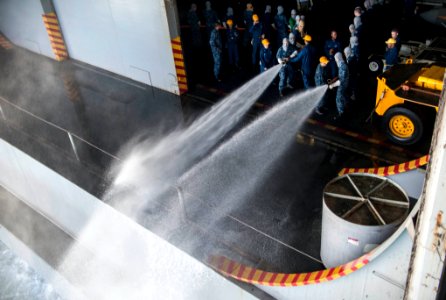 U.S. Sailors practice proper hose technique during a general quarters drill in the hangar bay of the aircraft carrier USS Harry S. Truman (CVN 75) in the Persian Gulf Jan. 17, 2014 140117-N-ZG705-073