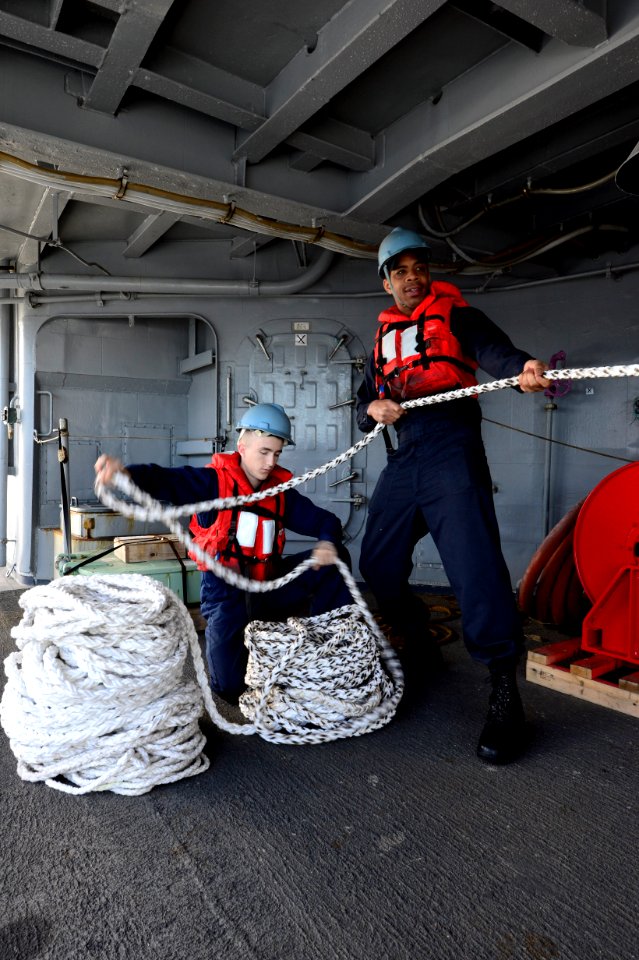 U.S. Navy Quartermaster Seaman Recruit Seth Dubinski, left, and Culinary Specialist 2nd Class Ontario Williams handle rope during a replenishment at sea aboard the guided missile cruiser USS Philippine Sea (CG 140223-N-PJ969-067