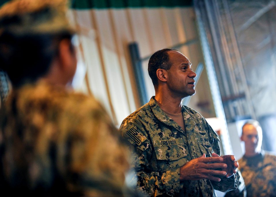 U.S. Navy Rear Adm. Vincent Griffith, center, the commander of Naval Supply Systems Command, Global Logistics Support, speaks to Sailors with the Camp Lemonnier supply department during a tour of the camp 140115-N-LE393-075