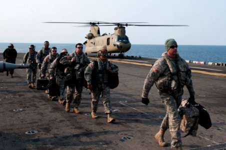 U.S. Soldiers assigned to the 3rd General Support Aviation Battalion, 2nd Combat Aviation Brigade, 2nd Infantry Division disembark from an Army CH-47F Chinook helicopter on the flight deck of the amphibious 140411-N-LM312-049 photo