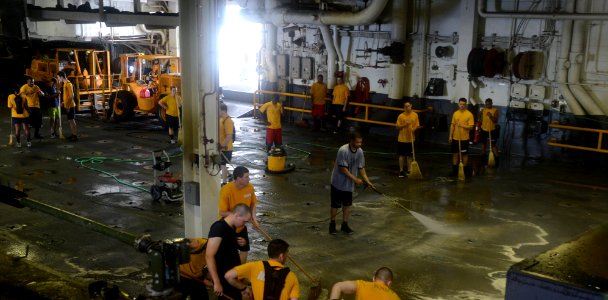 U.S. Sailors scrub the deck aboard the amphibious assault ship USS Bataan (LHD 5) March 25, 2014, in the Arabian Sea 140325-N-MW280-244