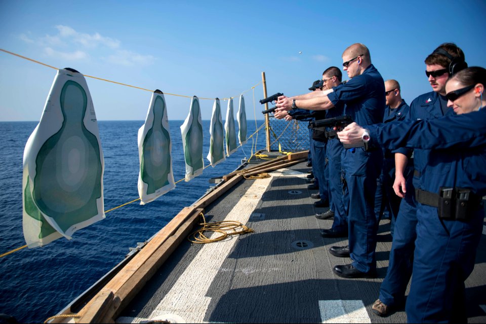 U.S. Sailors fire 9 mm pistols during security reaction force basic training aboard the guided missile destroyer USS Stout (DDG 55) Jan. 18, 2014, in the Mediterranean Sea 140118-N-UD469-535