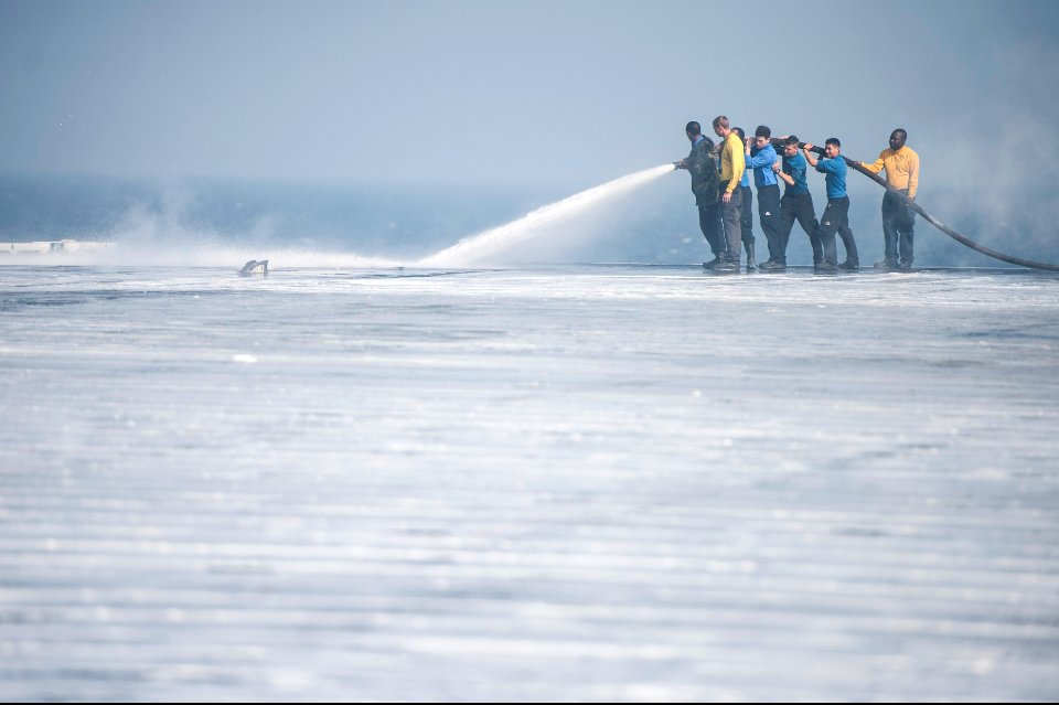 U.S. Sailors wash the flight deck of the aircraft carrier USS Harry S. Truman (CVN 75) March 16, 2014, in the Gulf of Oman 140316-N-ZG705-468