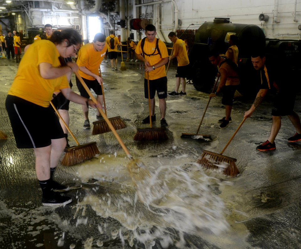 U.S. Sailors scrub the deck aboard the amphibious assault ship USS Bataan (LHD 5) March 25, 2014, in the Arabian Sea 140325-N-MW280-229