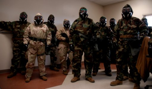 U.S. Sailors with Naval Mobile Construction Battalion (NMCB) 25 receive instructions after donning mission-oriented protective posture gear during a simulated chemical attack during chemical, biological 140214-N-JP566-058