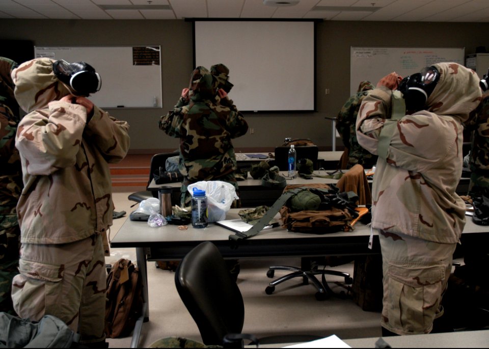 U.S. Sailors with Naval Mobile Construction Battalion (NMCB) 25 don mission-oriented protective posture gear during a simulated chemical attack during chemical, biological and radiological (CBR) team training 140214-N-JP566-019