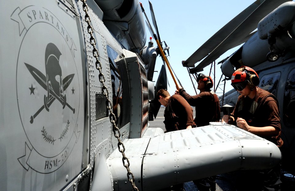 U.S. Sailors wash an MH-60R Seahawk helicopter assigned to Helicopter Maritime Strike Squadron (HSM) 70 aboard the aircraft carrier USS George H.W. Bush (CVN 77) in the Persian Gulf June 26, 2014 140626-N-MU440-014