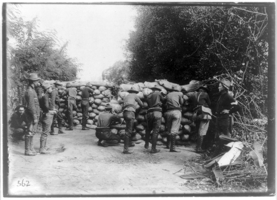 U.S. soldiers firing from behind sandbag breastworks, Philippines LCCN2016650354
