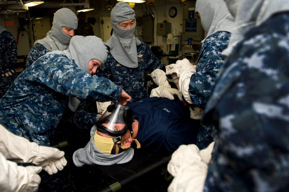 U.S. Sailors assigned to the medical department aboard the newly commissioned amphibious assault ship USS America (LHA 6) examine a Sailor with a simulated injury Sept 140906-N-MD297-040