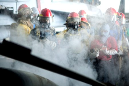 U.S. Sailors fight a simulated fire during a general quarters drill in the hangar bay of the aircraft carrier USS Harry S. Truman (CVN 75) March 8, 2014, in the Gulf of Oman 140308-N-ZG705-415