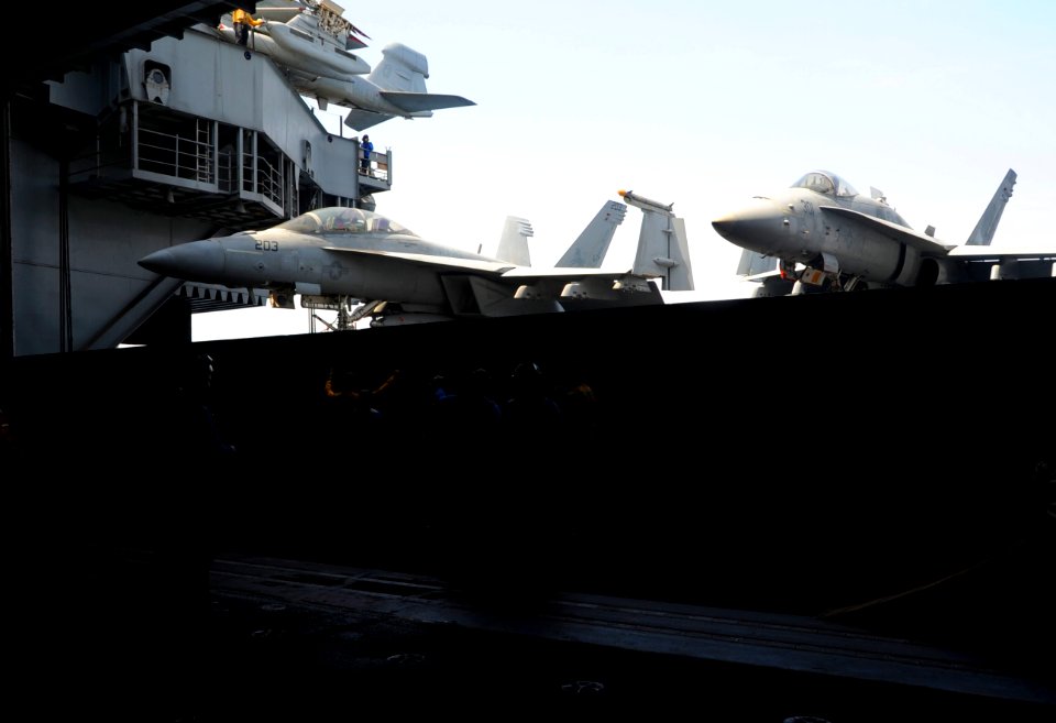 U.S. Sailors move aircraft into the hangar bay aboard the aircraft carrier USS George H.W. Bush (CVN 77) June 30, 2014, in the Persian Gulf 140630-N-MU440-006