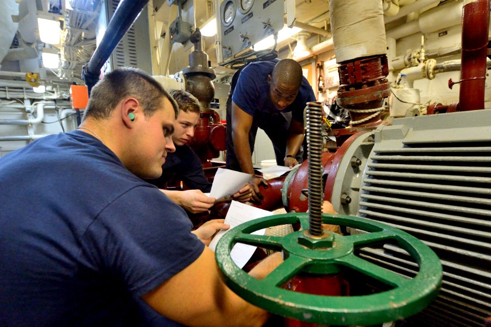 U.S. Sailors review instructions before performing maintenance on a fire pump aboard the guided missile destroyer USS Ross (DDG 71) Aug. 25, 2014, at Naval Support Activity Souda Bay, Greece 140825-N-IY142-026