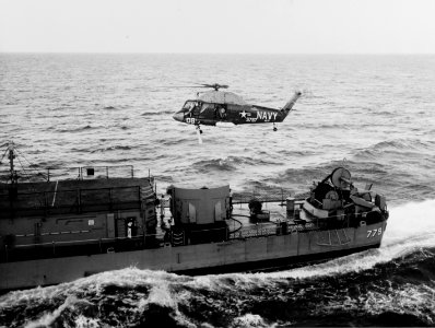 UH-2A Seasprite of HU-2 hovers over stern of USS Douglas H. Fox (DD-779) in August 1964