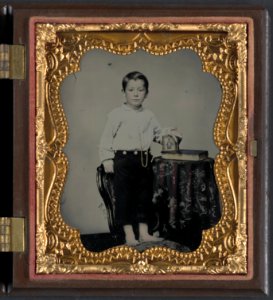 Unidentified boy holding cased photograph of soldier in Confederate uniform atop a Bible) - Rees LCCN2012646132