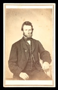 Unidentified bearded man sitting in chair, arm resting on table top) - J.G. Stacy, Dover, Me LCCN2016653192
