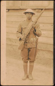 Unidentified African American soldier in uniform and helmet with rifle and knife hanging from cartridge belt LCCN2017648676
