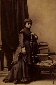 Unidentified Hawaiian woman wearing western dress and leaning against chair, photograph by H. L. Chase, Mission Houses Museum Archives