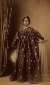 Unidentified Hawaiian woman wearing floral holoku, photograph by H. L. Chase, Mission Houses Museum Archives