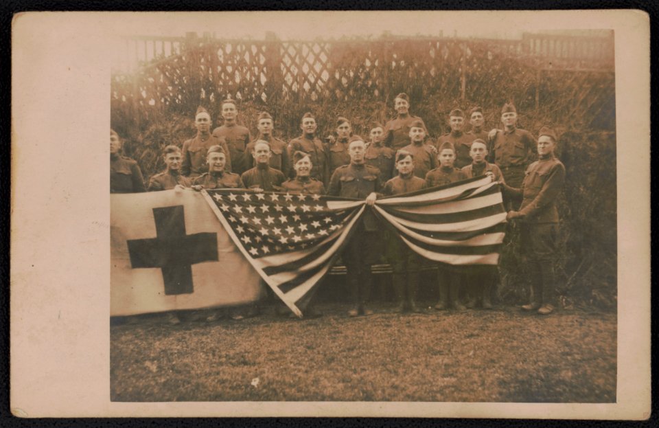Unidentified soldiers of Army medical company in uniform with American flag and red cross banner LCCN2018645975