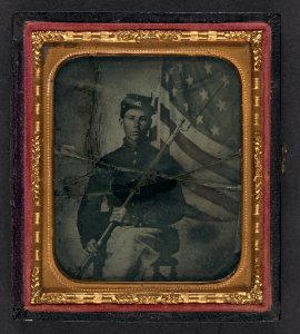 Unidentified soldier in Union uniform with bayoneted musket in front of American flag photo