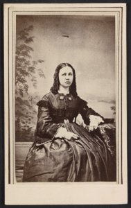 Unidentified woman in front of painted backdrop showing landscape LCCN2012647147