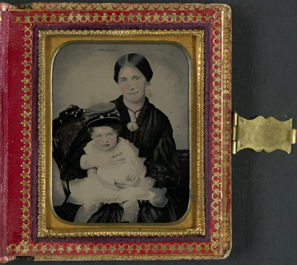 Unidentified woman, possibly Mrs. James Shields, in mourning dress and brooch showing Confederate soldier and holding young boy wearing kepi LCCN2013649140