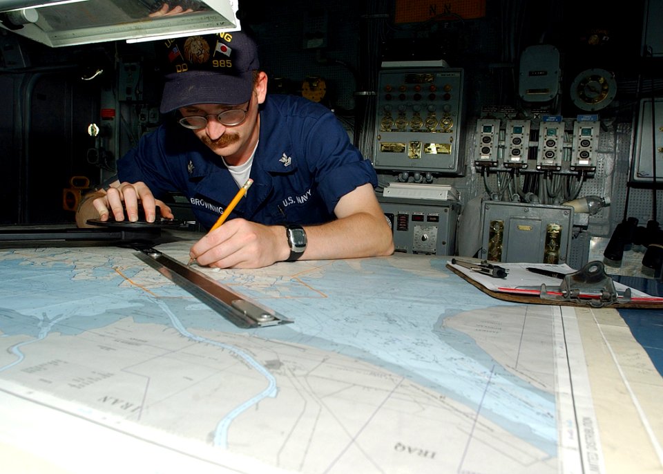 US Navy 020627-N-4374S-007 Quartermaster plots ship's position on the bridge
