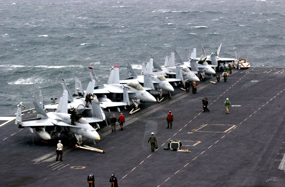 US Navy 020924-N-2385R-003 F-A-18 'Hornet' and 'Super Hornet' strike fighters stand ready on the ship's forward flight deck