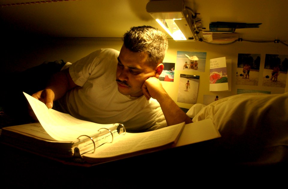US Navy 021022-N-4309A-128 At sea aboard USS Reuben James (FFG 57) Oct. 22, 2002 - Damage Controlman 1st Class David Hernandez studies his Enlisted Surface Warfare Specialist (ESWS) books in his rack aboard the guided missile