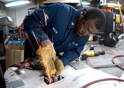 US Navy 020901-N-6433N-001 Hull Technician uses a grinder in he ships