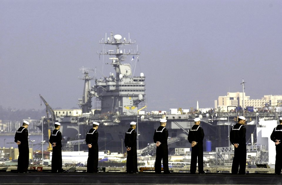 US Navy 021102-N-4142G-057 Sailors man the rails as the aircraft carrier Constellation steams past the nuclear powered aircraft carrier USS John C. Stennis (CVN 74)