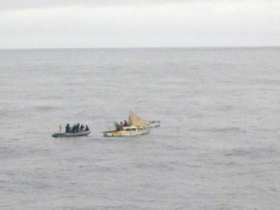 US Navy 020917-N-0000X-012 U.S. Sailors render assistance to a sailboat adrift at sea photo