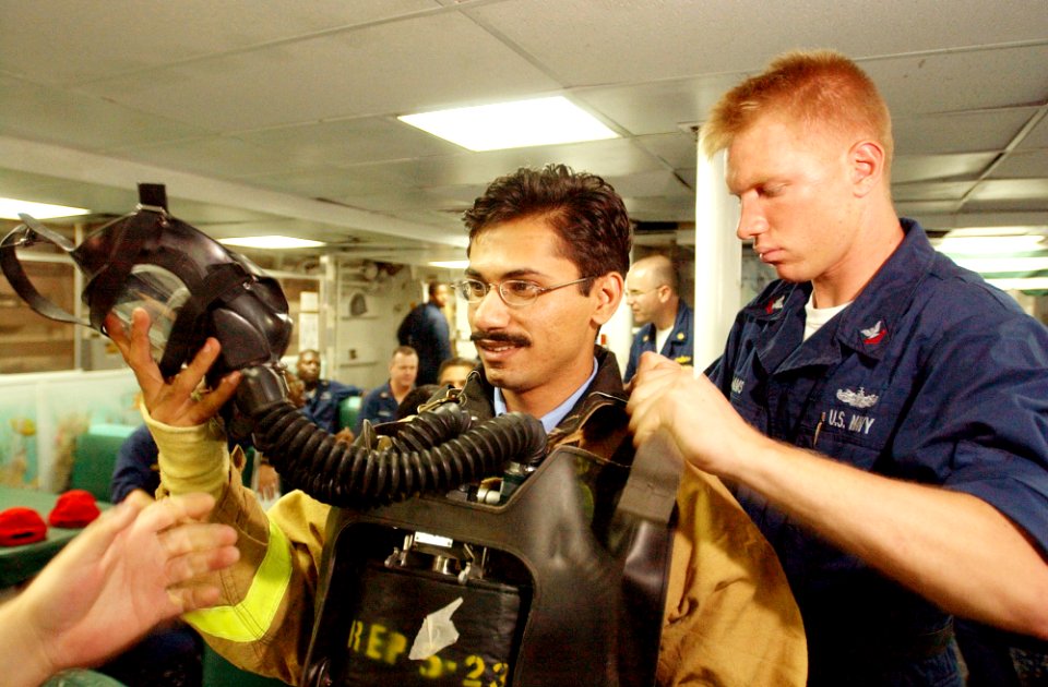 US Navy 020924-N-4309A-030 Damage Controlman assists with the firefighting gear of Pakistani Lieutenant from the Pakistani ship Tippu Sultan (DDG 185)