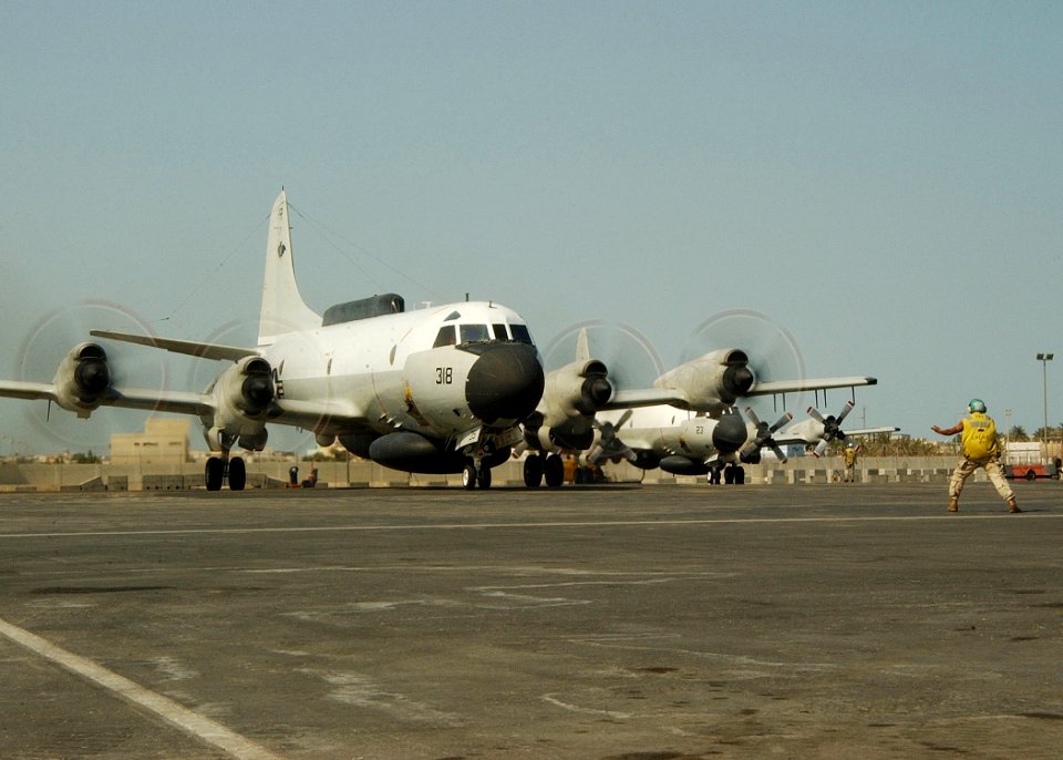 US Navy 021024-N-4374S-036 Plane Captain, Aviation Electronics Technician 3rd Class Timothy Adams, gives a reverse command to a pilot as he guides his EP-3E Aries II