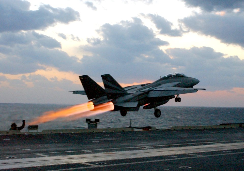 US Navy 021114-N-1810F-018 An F-14 Tomcat assigned to the Black Knights of Fighter Squadron One Five Four (VF-154) launches past steaming catapults on the bow of the ship