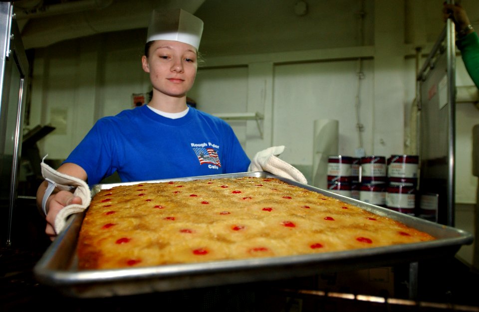 US Navy 021205-N-1328C-504 pulling out a fresh tray of Pineapple Upside Down Cake