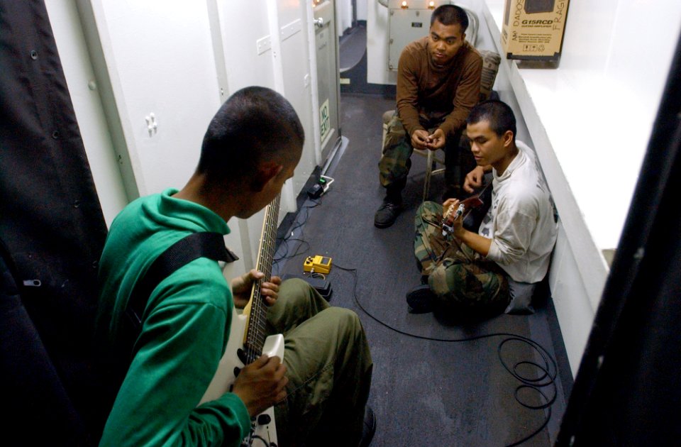 US Navy 021003-N-4309A-010 While others enjoyed their steel beach picnic on the flight deck or playing various sports, these crewmembers took the opportunity to play their guitars together in a passageway aboard the ship
